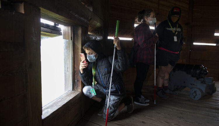 Above, seventh-grader Dezmynd Cantu, left, kneels to snap a photo while touring the bastion at Fort Vancouver National Historic Site with classmate Brianna Hoefliner and paraeducator Jared Miller-Price.